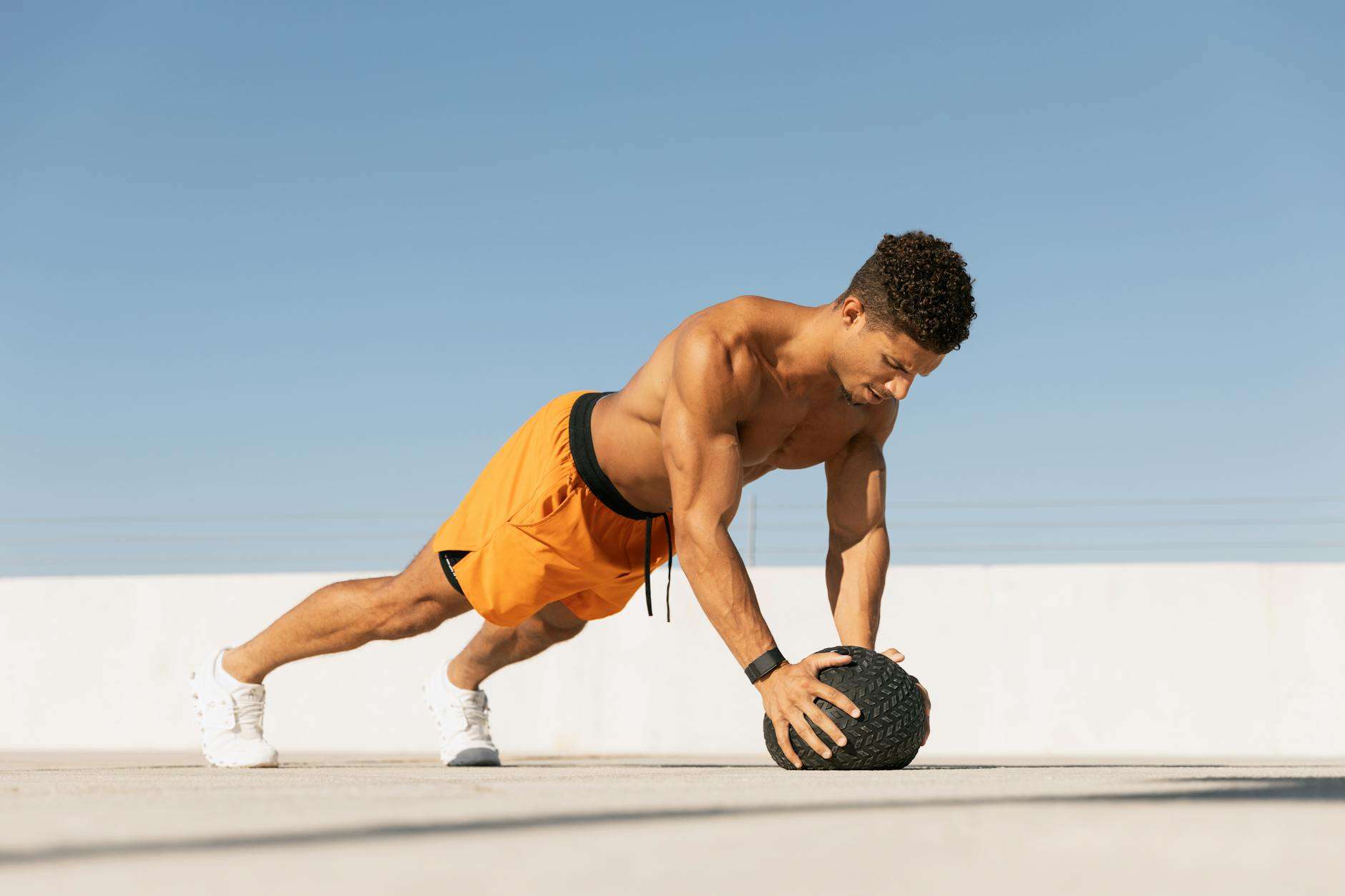 man exercising with medicine ball on rooftop