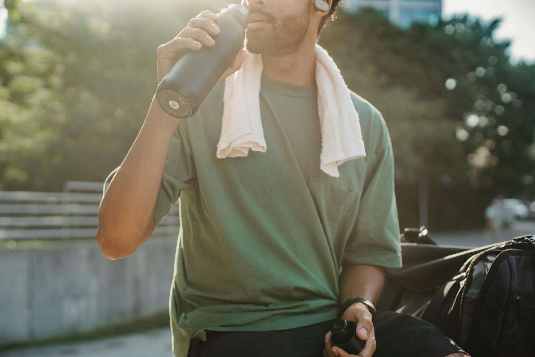 Man Drinking Water In a Park