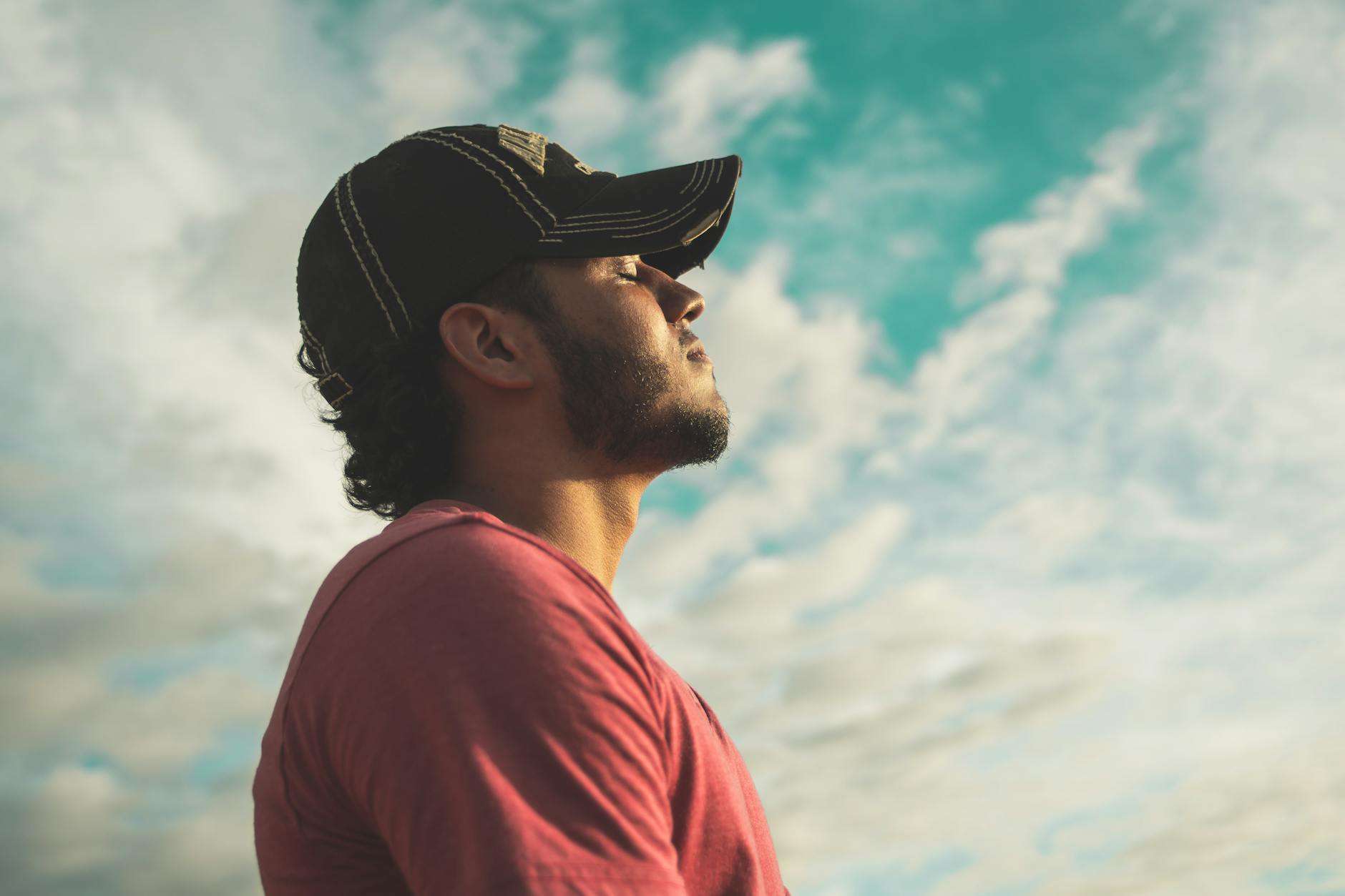 https://www.pexels.com/photo/man-wearing-black-cap-with-eyes-closed-under-cloudy-sky-810775/